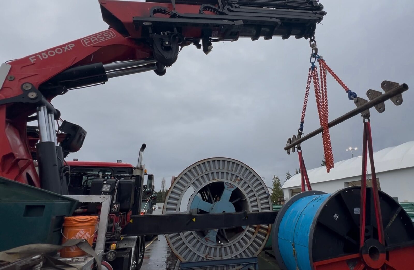 CraneX crane offloading a large cable reel using a spreader bar