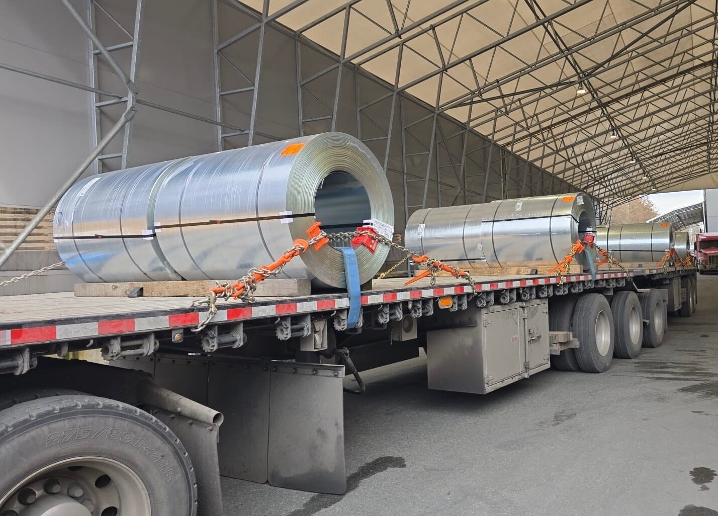 CraneX flat deck trailer loaded with large aluminium coils