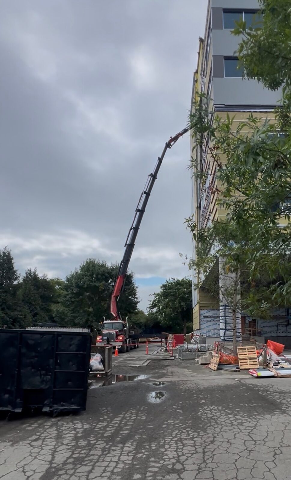 CraneX boom extended up a high-rise to lift a Genie lift out of an upper floor